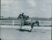 Prince Aly Khan riding a horse on a race track